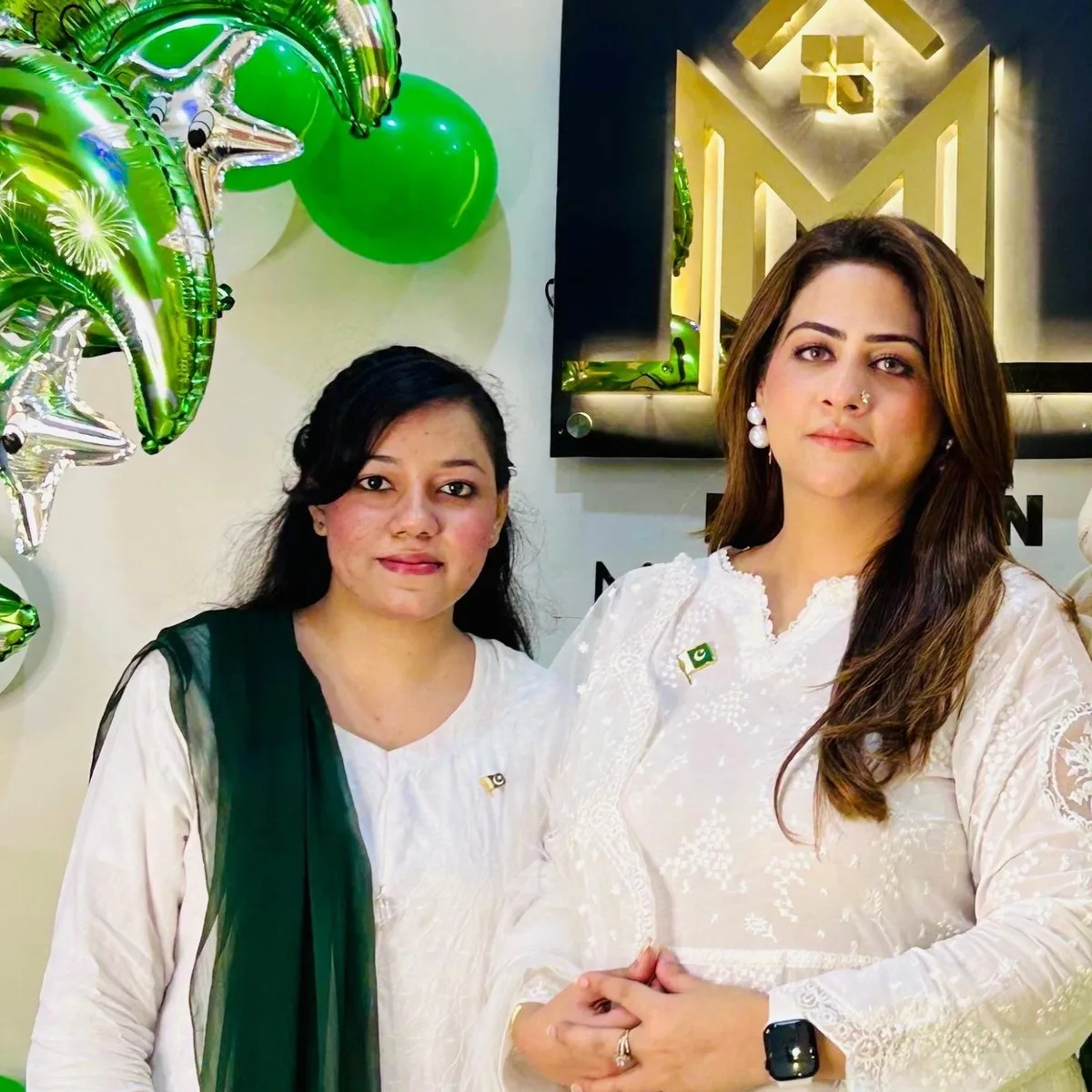 Yousfa Tariq and a team member standing in front of the Maskan Marketing sign at the office